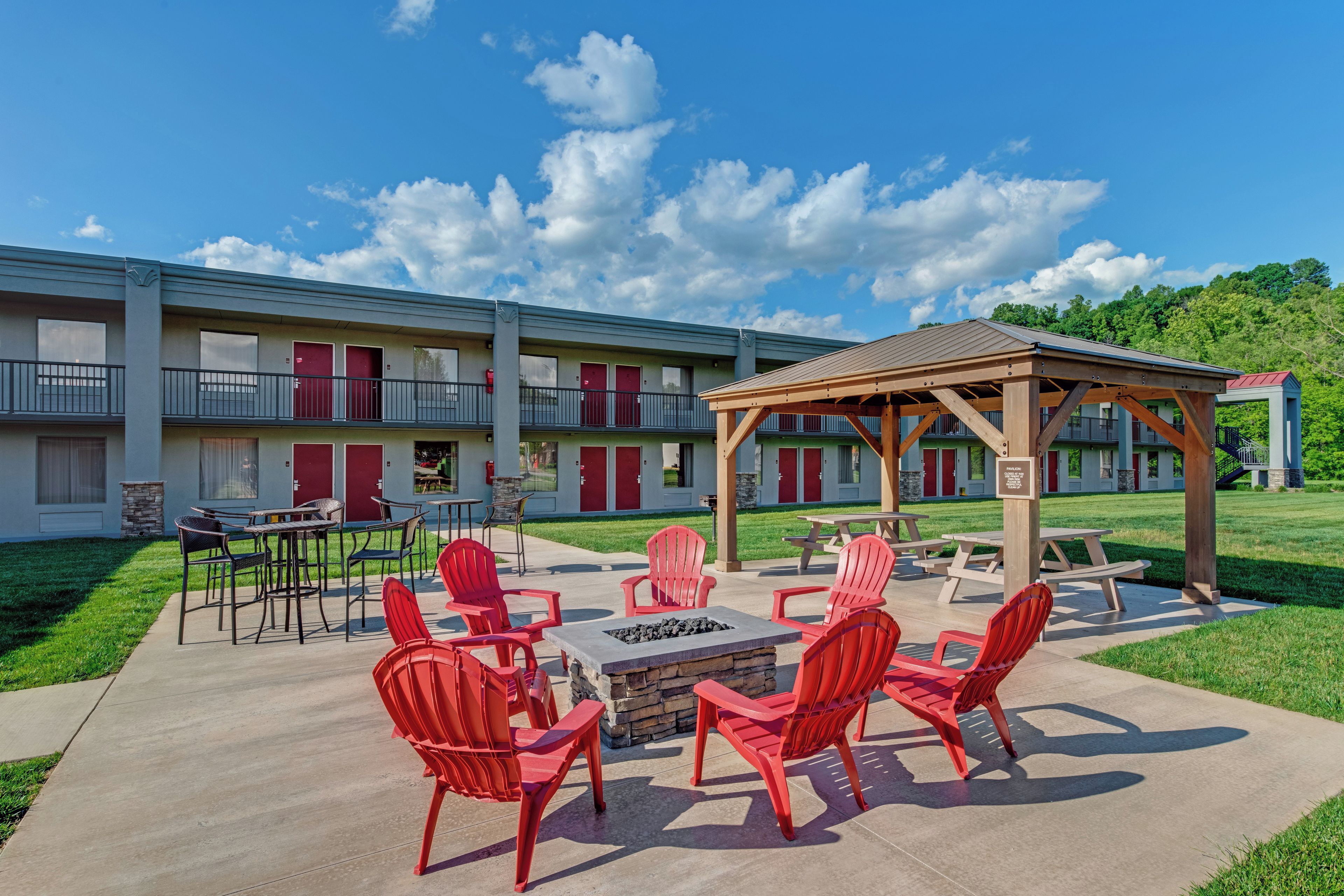 Un motel con asientos exteriores y un patio cubierto.