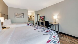 A hotel room with two beds, a desk, a television, and a mirror. - Red Roof Inn & Suites Wilkesboro (Wilkesboro)