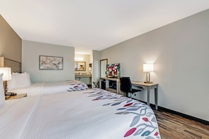A hotel room with two beds, a desk, a television, and a mirror. - Red Roof Inn & Suites Wilkesboro (Wilkesboro)
