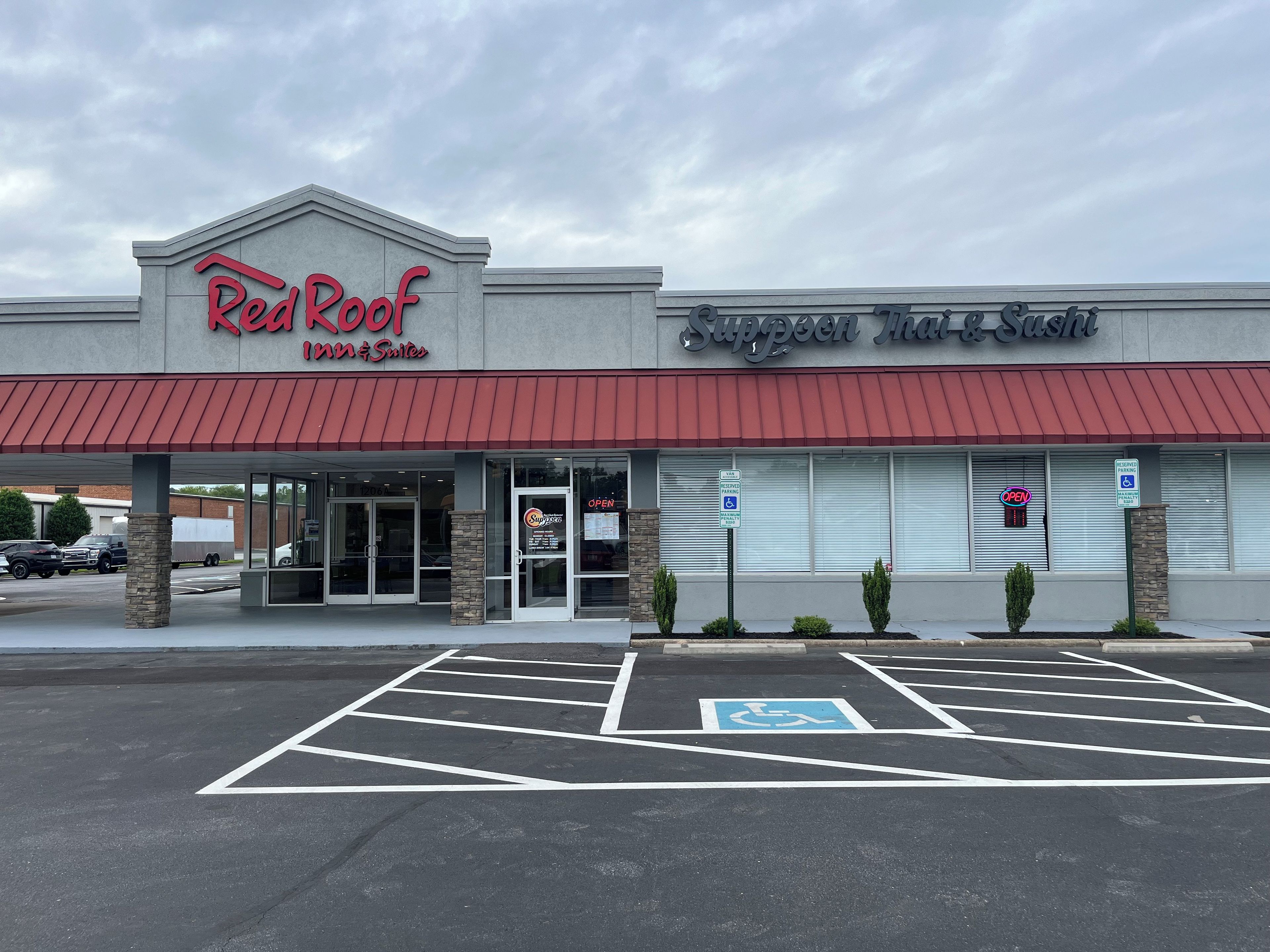 A building with a sign for Red Roof Inn & Suites and another for Suppleman Mac & Sushi.