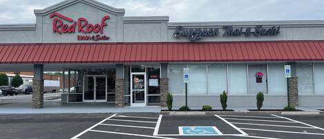 A building with a sign for Red Roof Inn & Suites and another for Suppleman Mac & Sushi.