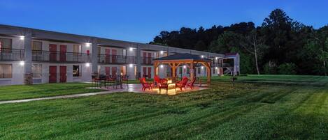 A multi-story hotel with outdoor seating and a fire pit area.