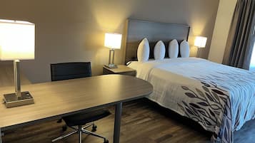 A hotel room with a bed, two bedside lamps, a desk with a chair, and a telephone.