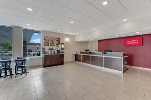 A hotel reception area with a modern design, including a reception desk, seating area, and artwork on the walls. - Red Roof Inn & Suites Wilkesboro (Wilkesboro)