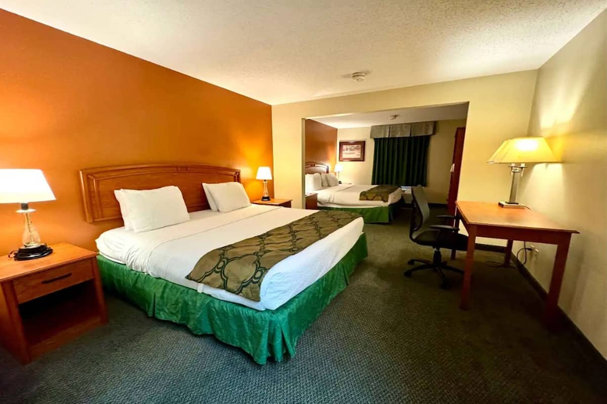 Une chambre d’hôtel avec un lit simple, un bureau et une chaise.