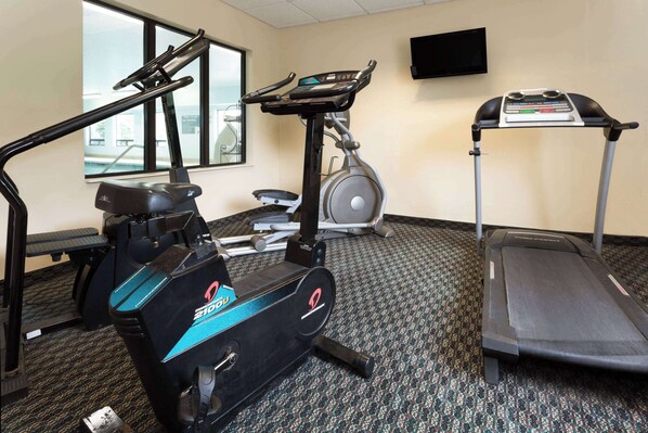 Stay active with a fully equipped fitness room featuring a stationary bike, elliptical trainer, and treadmill.