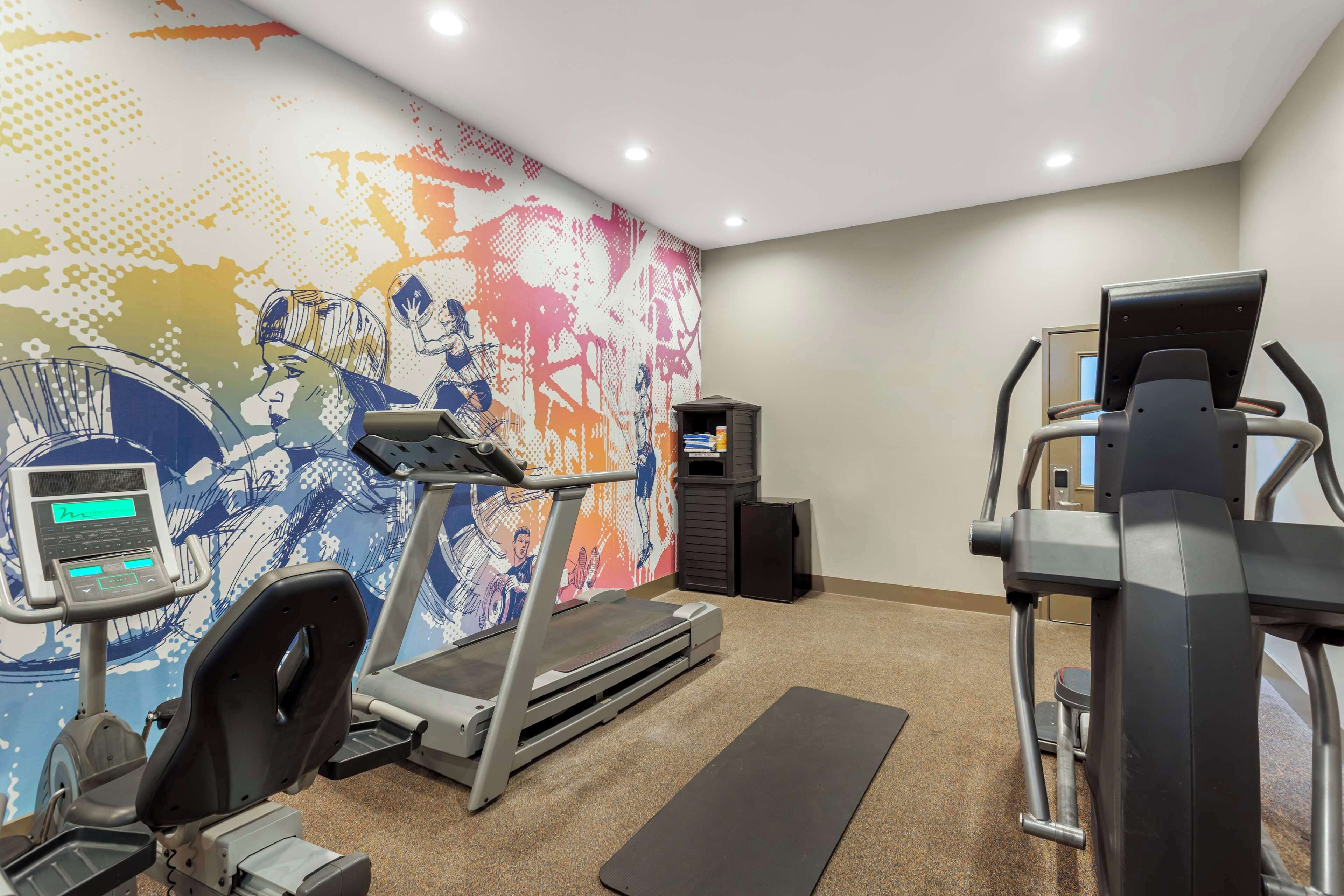 A gym with treadmills, a stationary bike, and a rowing machine.