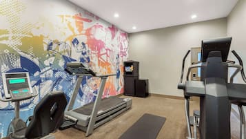 A gym with treadmills, a stationary bike, and a rowing machine.