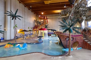 Un parc aquatique intérieur doté d’un espace de jeux sur le thème des bateaux, de toboggans et d’une piscine.