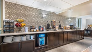 A hotel reception area with a herringbone-patterned wall, a fruit bowl, a beverage cooler, and a coffee machine. - Best Western Plus Calgary Centre Inn (Calgary)