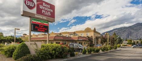 Un hotel con un gran cartel de Best Western Plus y Quizno's Sub.