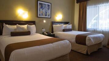 A hotel room with two beds, a nightstand, a phone, and a painting on the wall.