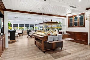 A buffet setup with a wooden counter, plates, and various food items. - Best Western Laegreid Hotell (Sogndal)