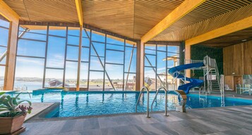 Una piscina techada, sillones reclinables de piscina