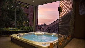 A hot tub in a modern room with a large window overlooking a mountainous landscape. - Casa Andina Premium Golf Los Incas (Santiago de Surco)