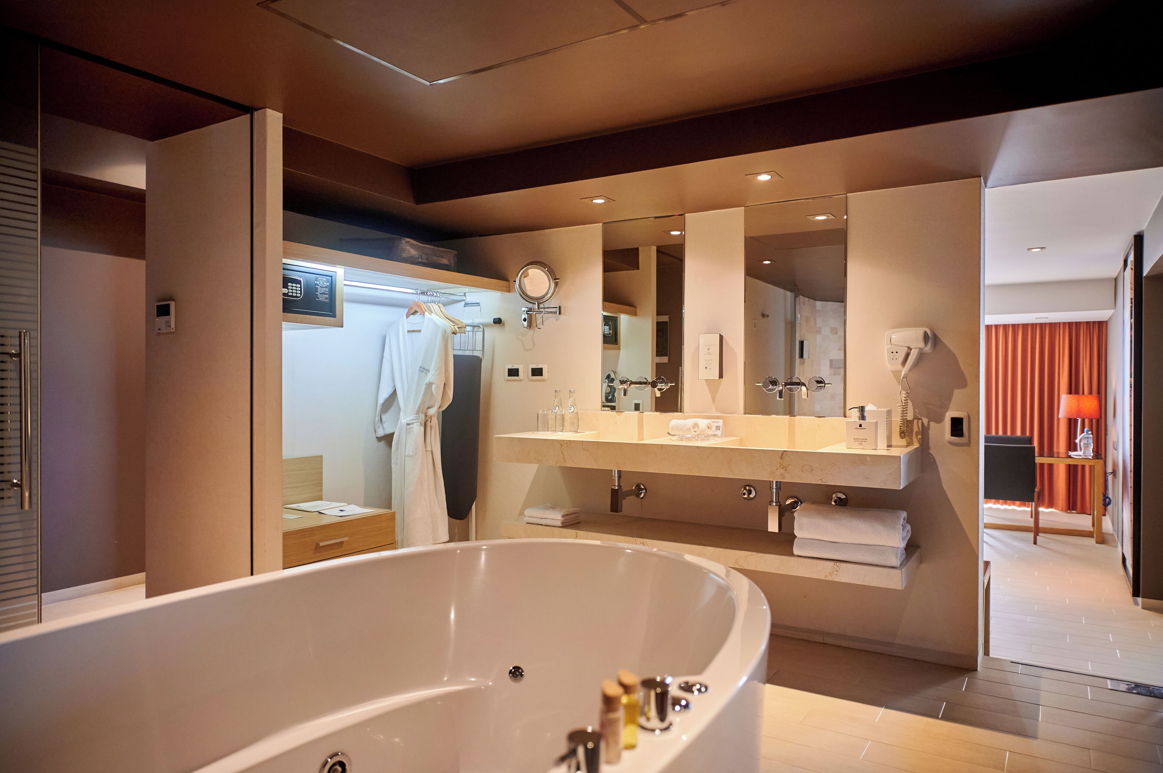 Un baño moderno con una bañera grande, un tocador con espejo y una zona de ducha.