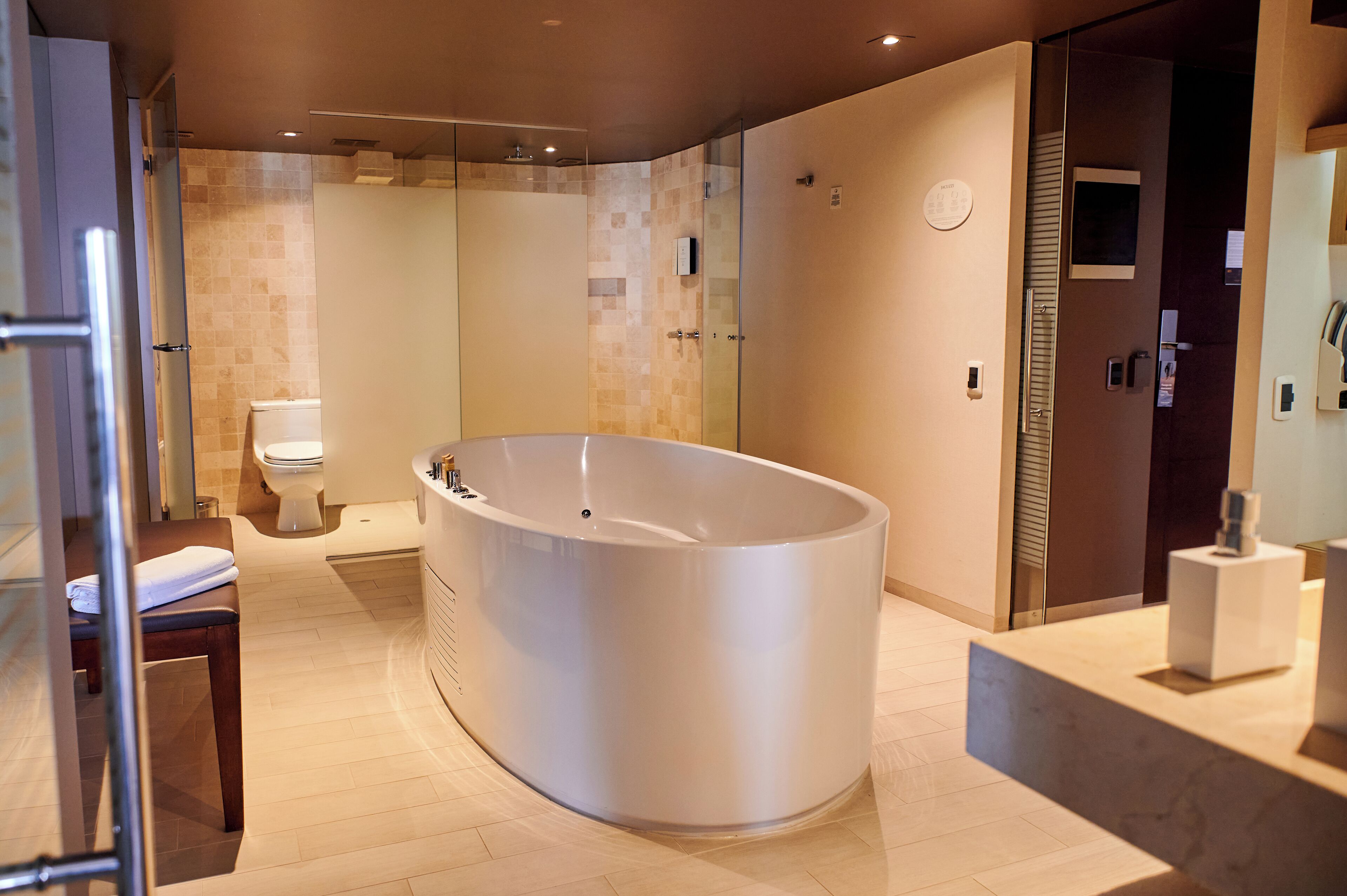 Une salle de bain moderne avec une baignoire sur pieds, des toilettes et une douche à parois de verre.