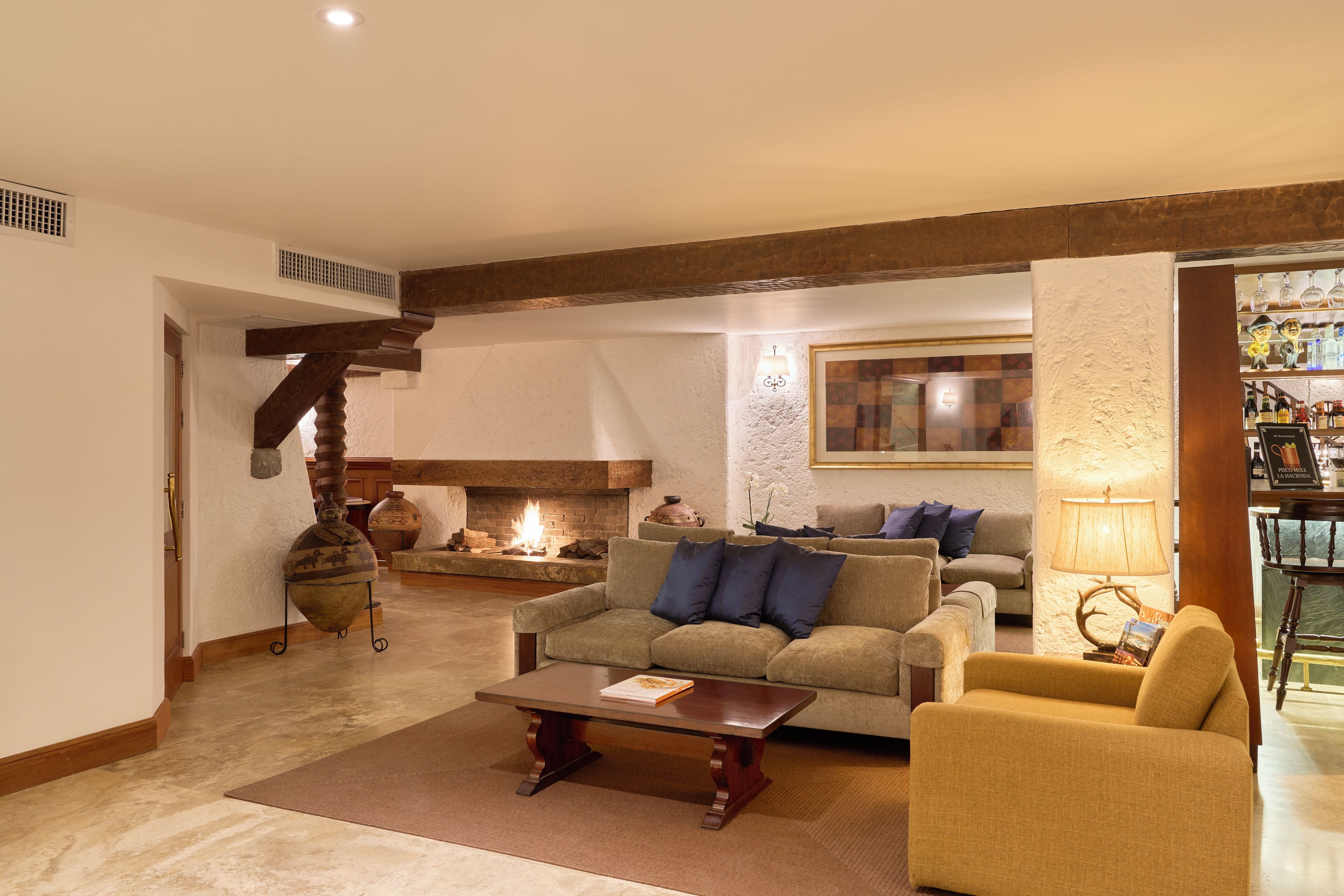 Una sala de estar acogedora con chimenea, un sofá, una mesa de centro y una estantería.