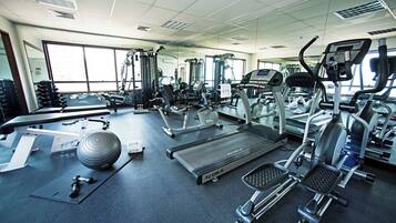 A gym with various exercise equipment including treadmills, a stationary bike, and free weights.