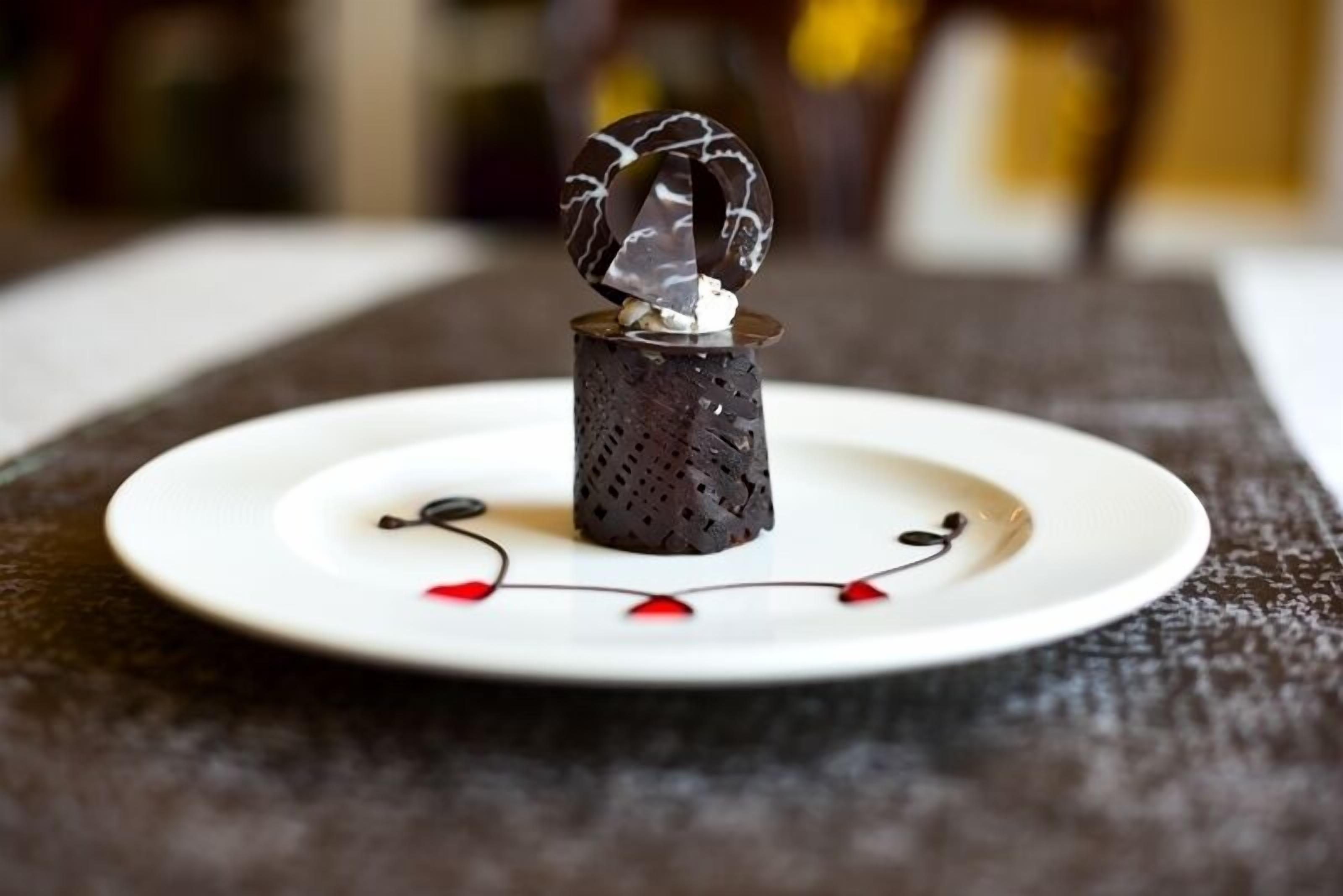 A dessert on a white plate with a decorative centerpiece.