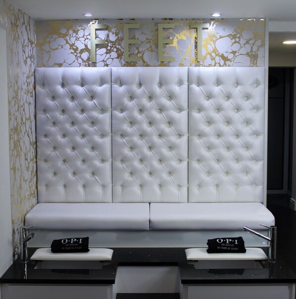 A modern reception area with a tufted white headboard, a black countertop, and a 'FREET' wall decoration. - Thornton Hall Hotel and Spa (Wirral)