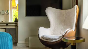 A modern room with a brown leather chair, a small round table, and a flat-screen TV mounted on the wall.