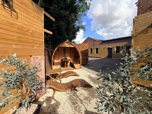 A wooden building with a covered outdoor seating area, a small table, and chairs. - Best Western Consort Hotel (Rotherham)