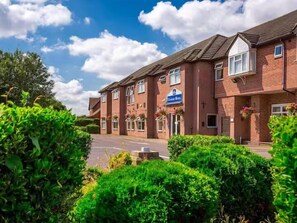 A row of brick buildings with a sign indicating a hotel. - Best Western Consort Hotel (Rotherham)