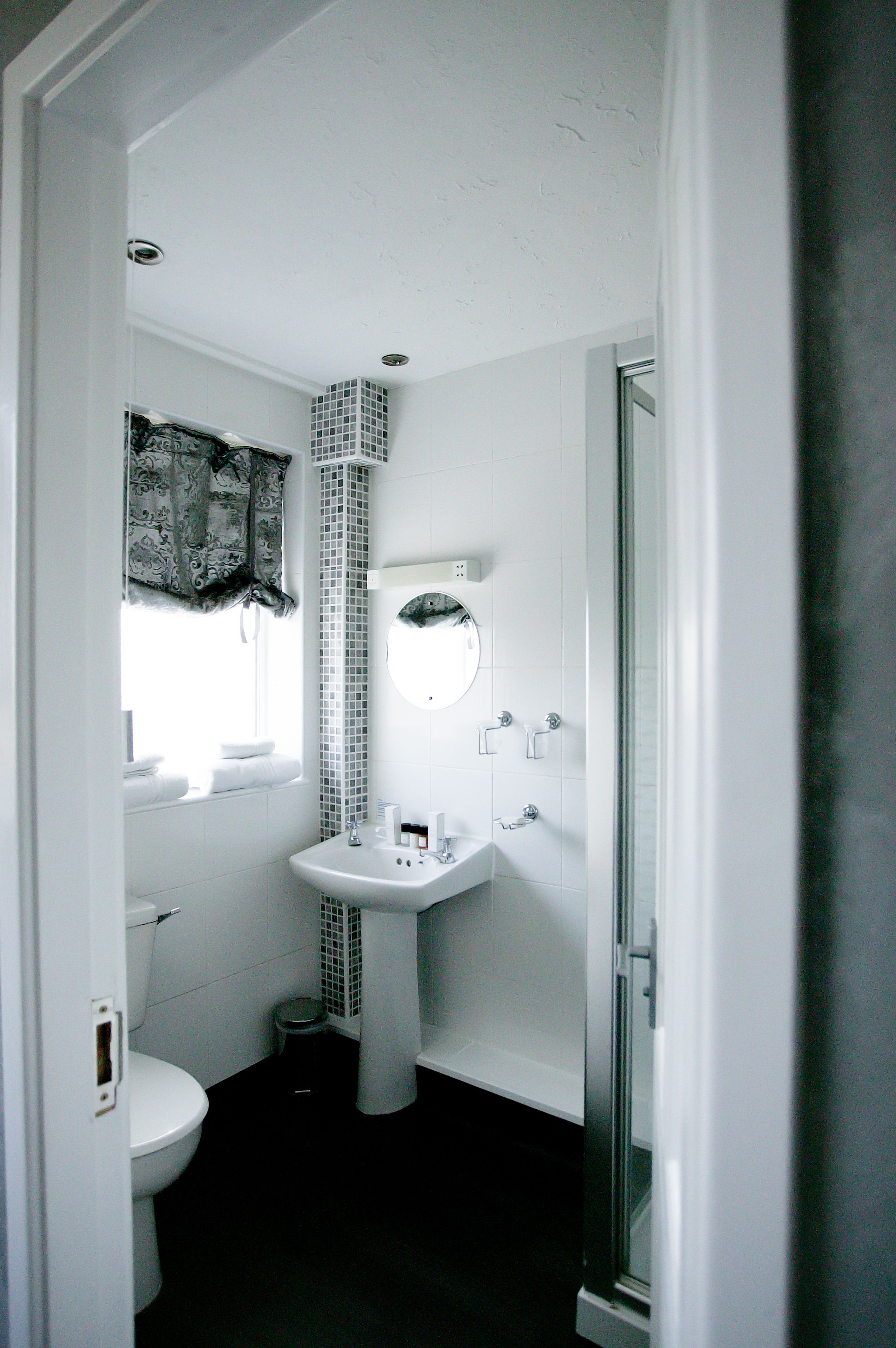 Un baño pequeño con inodoro, lavabo y ducha.