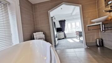 Une salle de bain moderne équipée d’une baignoire, d’un meuble-lavabo et d’un espace douche.