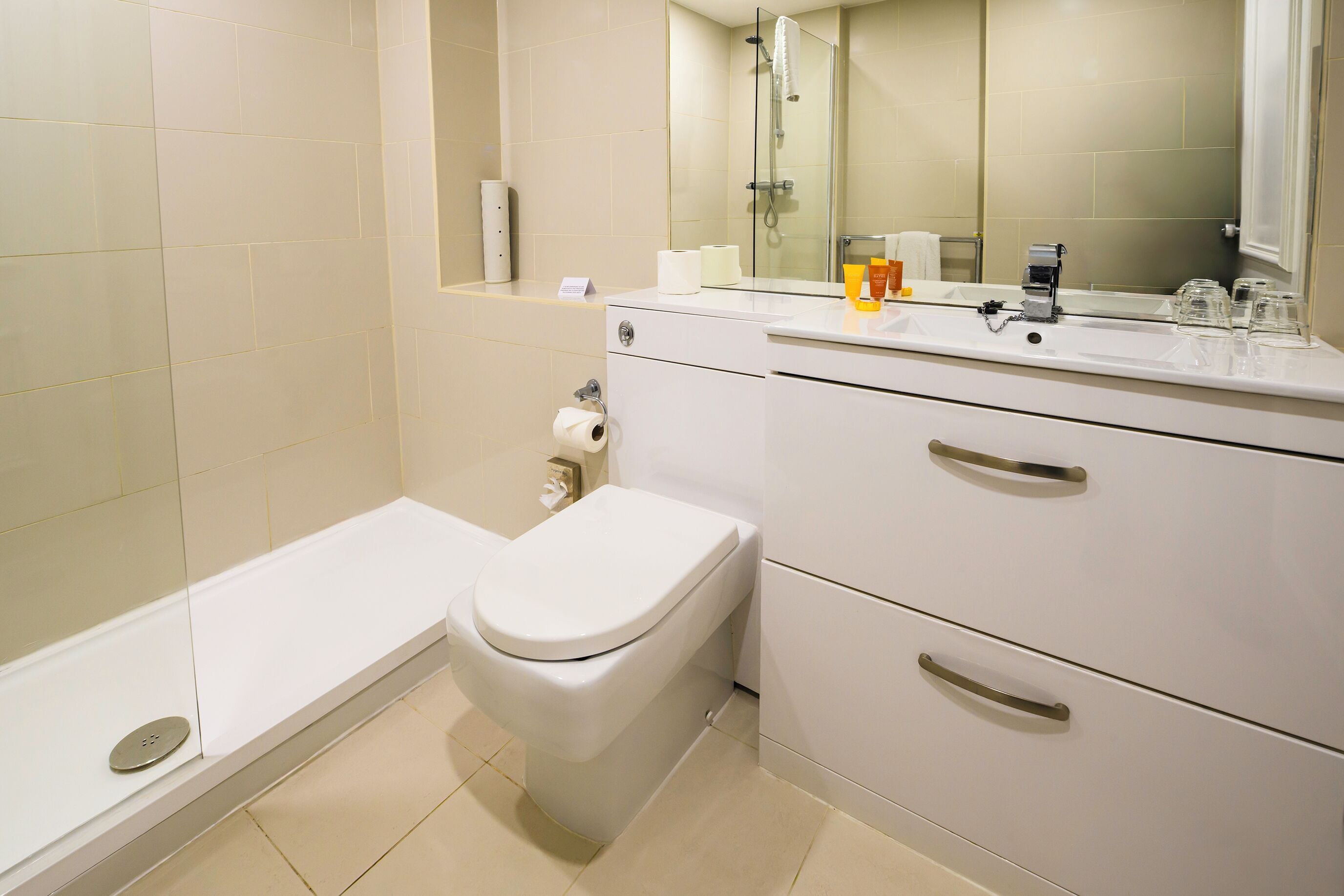 A modern bathroom with a toilet, a sink, and a shower area.