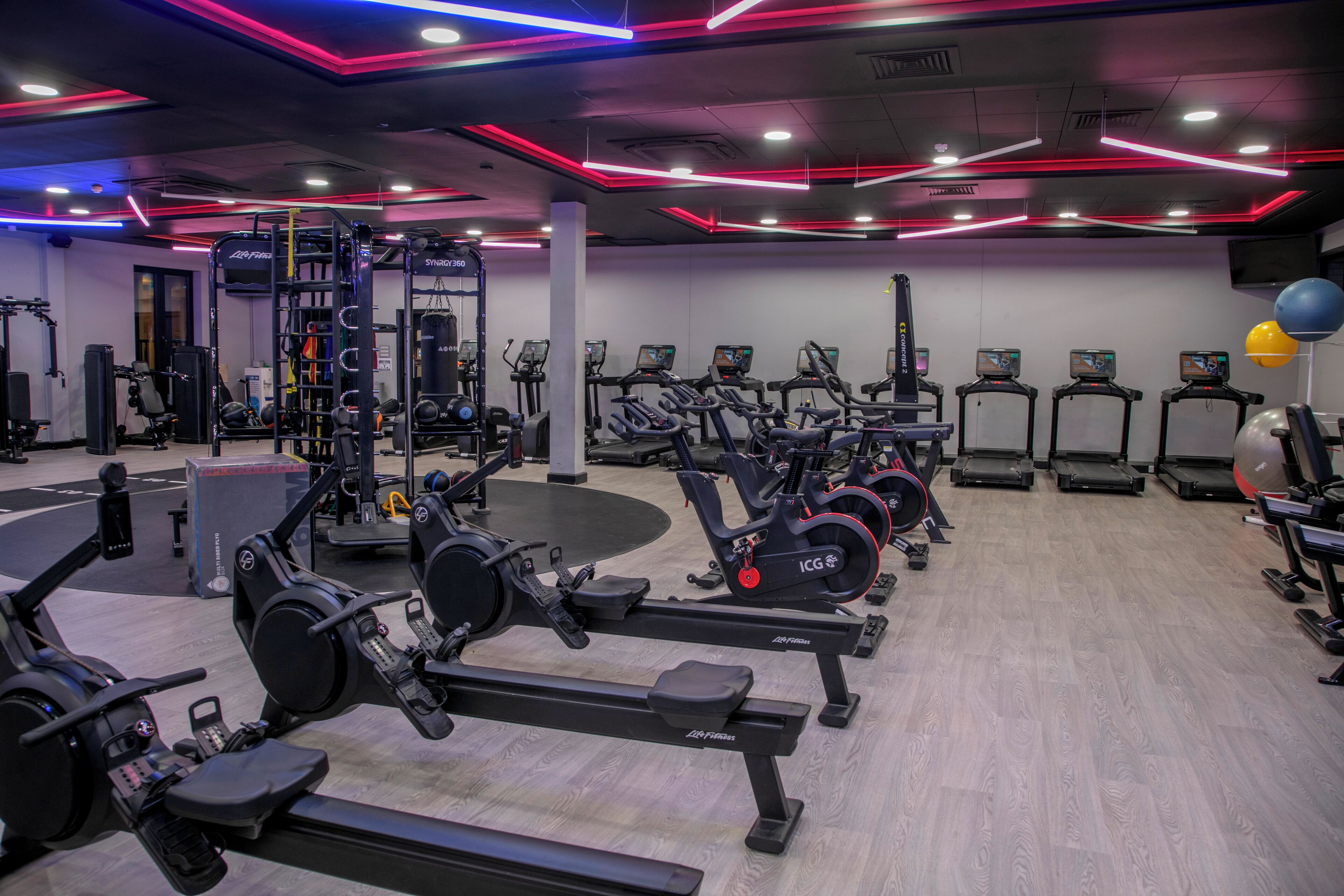 A gym with various exercise equipment including treadmills, elliptical machines, and weight machines.