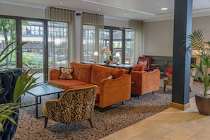 A hotel lobby with a sofa set, a coffee table, and a fireplace. - Hampshire Court Hotel & Spa (Basingstoke)
