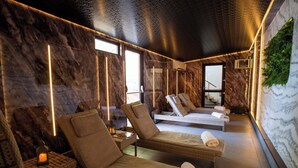 Un cuarto de spa con dos sillones reclinables, una camilla de masaje y un sillón de masaje de pared.