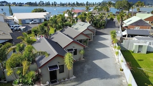 A coastal residential area with houses, a marina, and a mountain backdrop. - Tairua Shores (Tairua)