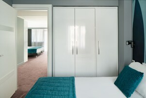 Een hotelkamer met een bed, een kledingkast en een badkamer zichtbaar door een open deur.