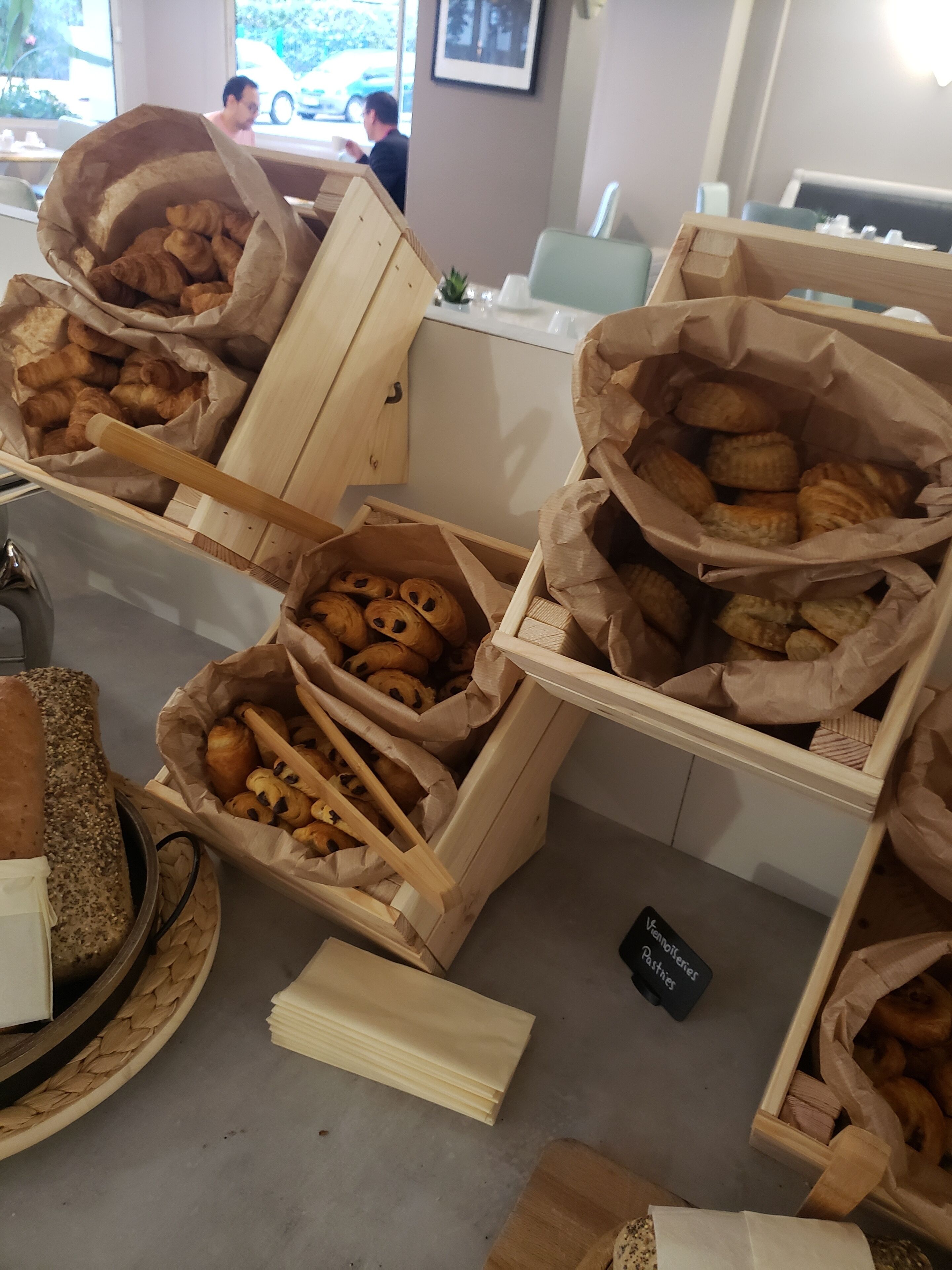 Ett bageridisplay med olika sorters bakverk i träkorgar.