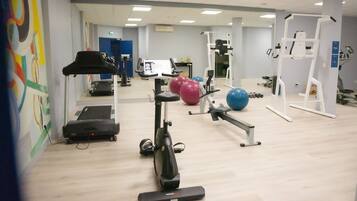 A gym with exercise equipment, a treadmill, and a stationary bike.