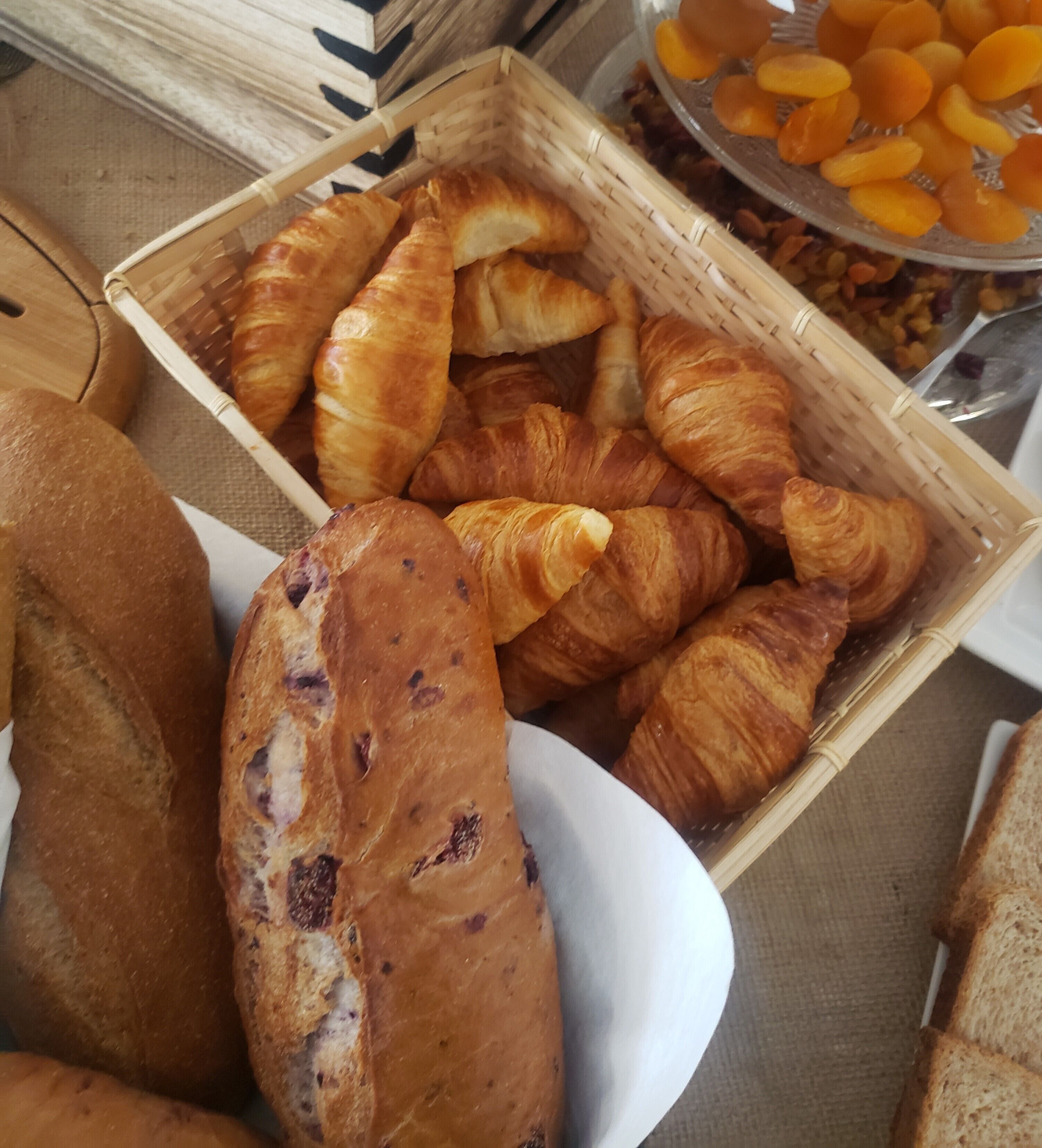 Diverse gebakjes, waaronder croissants en brood, uitgestald op een tafel.