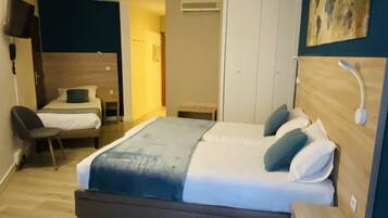 A bedroom with a large bed, a chair, a desk, and a wardrobe.