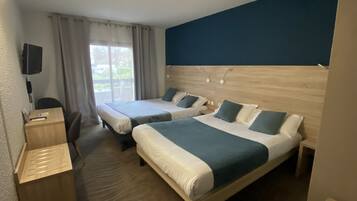 A hotel room with two beds, a desk, and a chair.