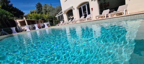 Piscine extérieure, parasols de plage, chaises longues