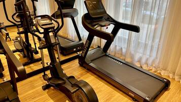Gimnasio en casa con cinta de correr, elíptica y bicicleta estática.
