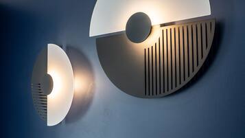 A wall-mounted light fixture with a circular design and a central illuminated bulb.