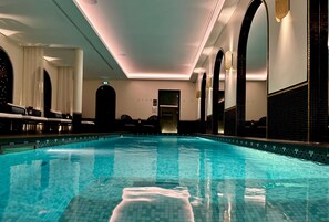 Una piscina cubierta, tumbonas