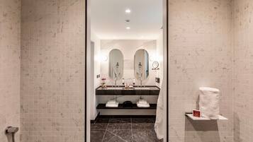 A modern bathroom with two sinks, a mirror, and a towel rack.