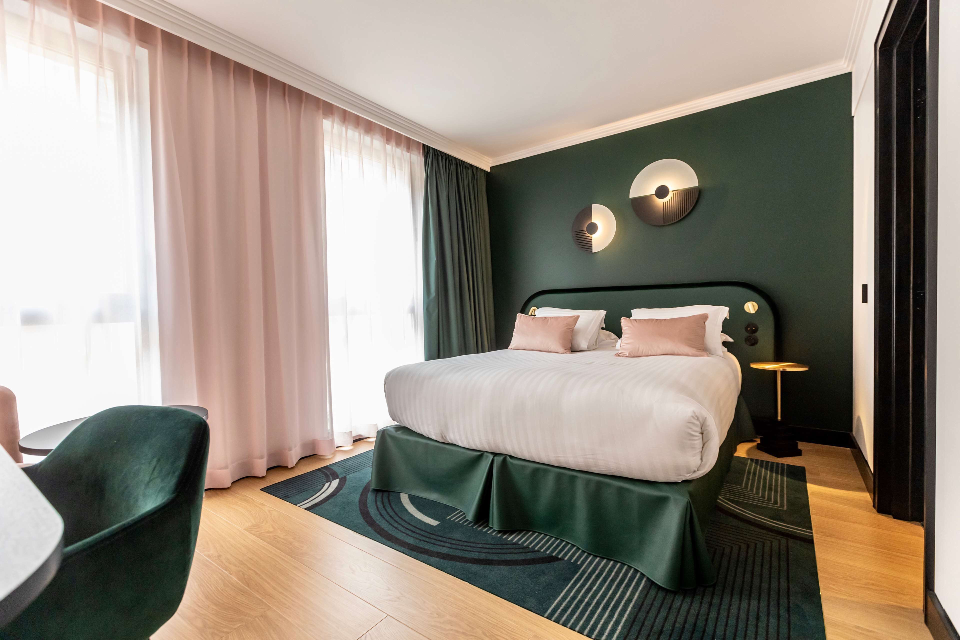 Een moderne hotelkamer met een groot bed, een bureau en uitzicht op de stad.