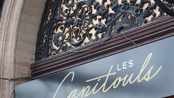 Experience the charm of LES Capitouls, a historic building with a beautifully detailed balcony.