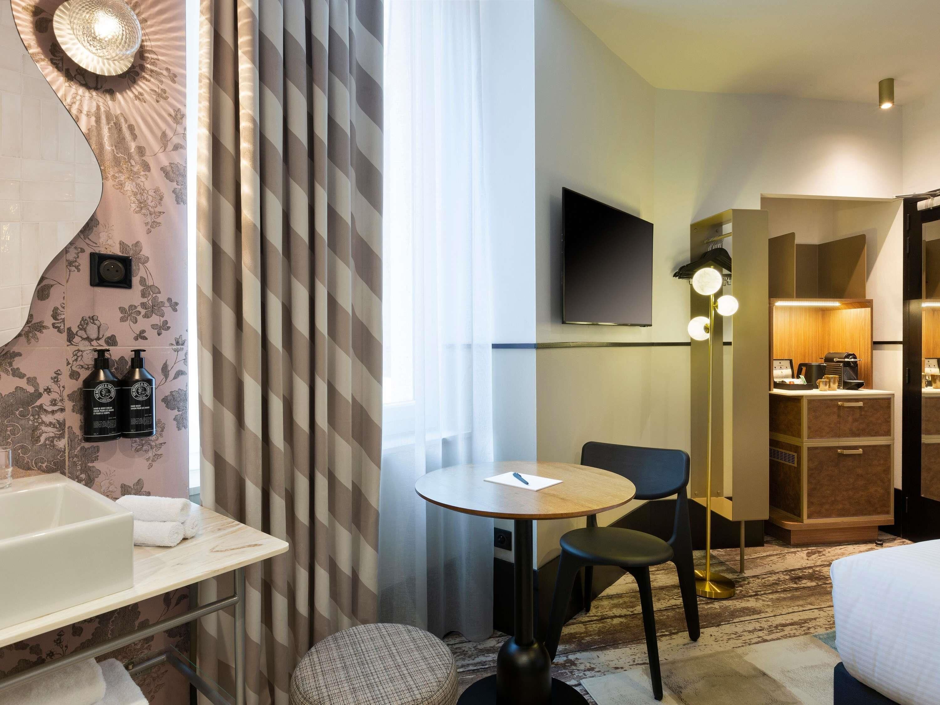 Een hotelkamer met een badkamer, een eethoek en een kitchenette.