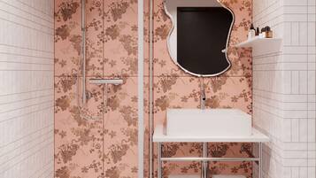 Une salle de bain avec une douche, un lavabo et un miroir.